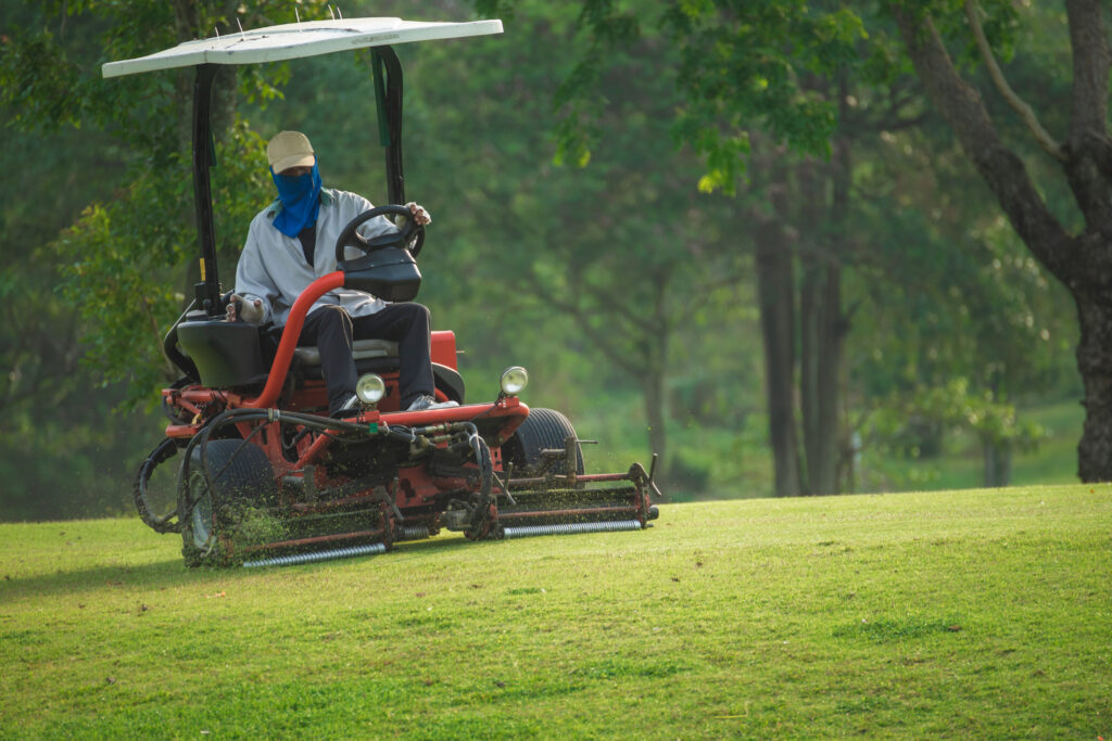 Workers taking care of the field are driving a mower.